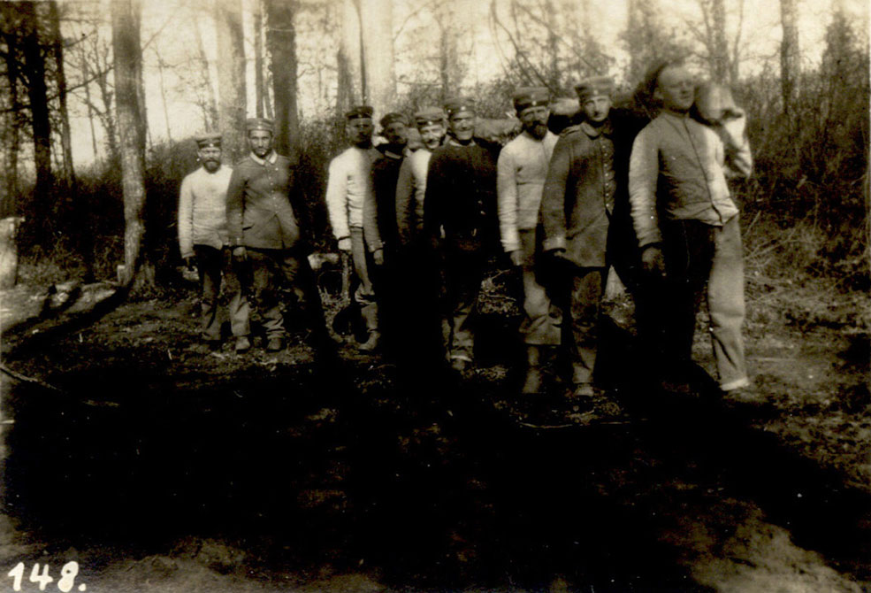 Arno and comrades from the group photo, transporting a log somewhere in the chateau grounds